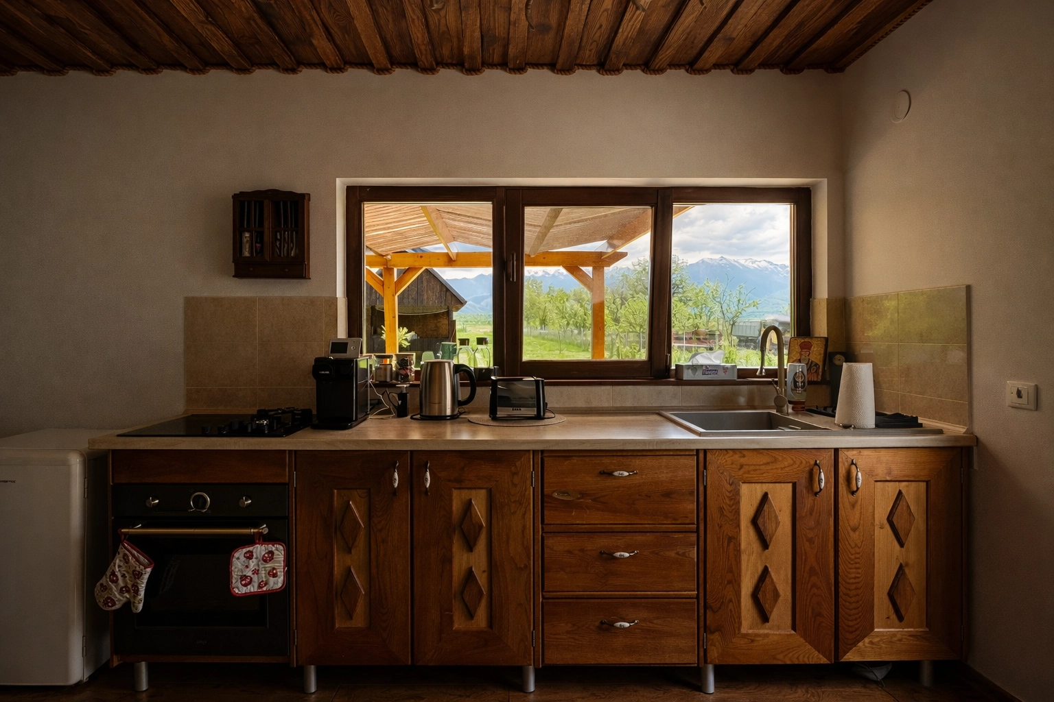 Bucătărie rustică cu plită electrică, cuptor și frigider